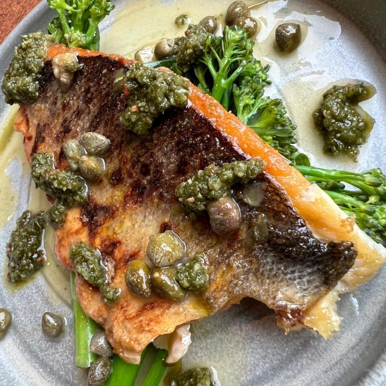 Fresh Seabass Fillet, with Tenderstem Broccoli, Lemon Caper Butter, and Chimichurri. Made to order, locally sourced, culinary excellence.